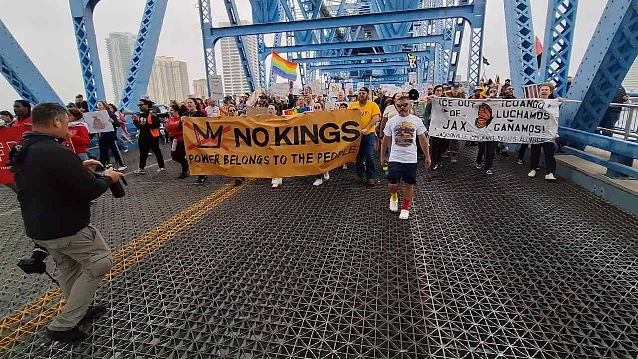 Thousands march across the Main Street Bridge toward the Duuval County Courthouse to participate in today's No Kings rally.